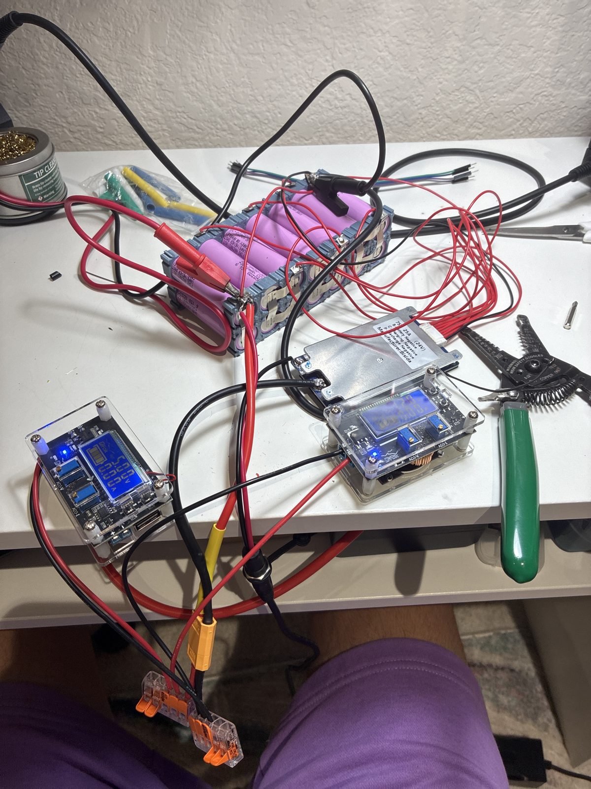 The 7S2P battery pack on the bench with BMS and two buck converters wired up